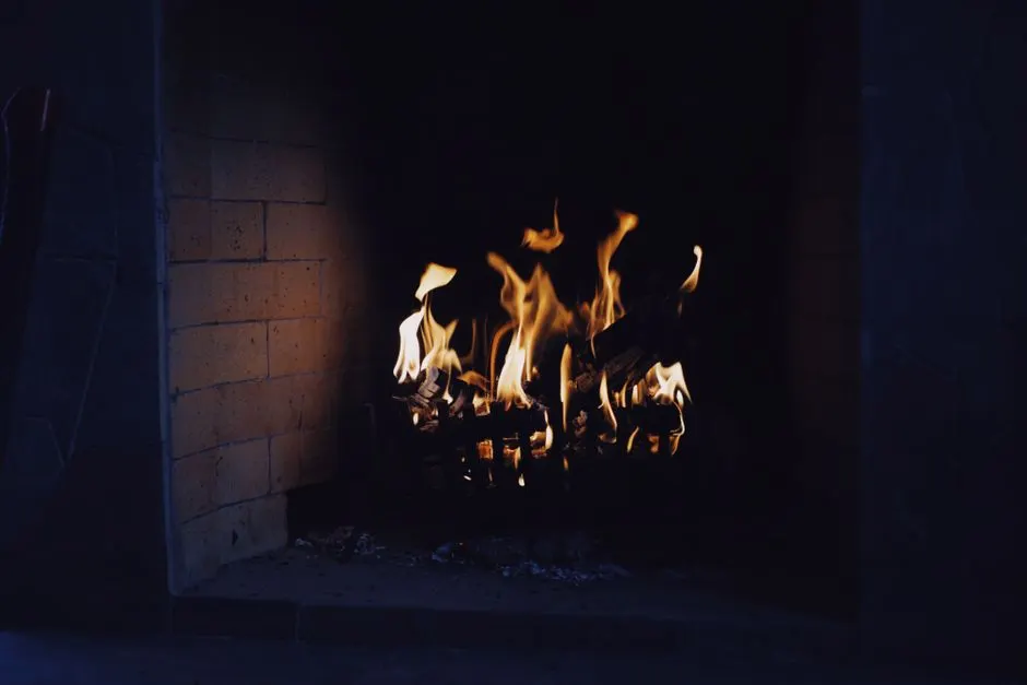 A close-up of a warm, inviting fireplace with flickering flames, perfect for a cozy interior setting.